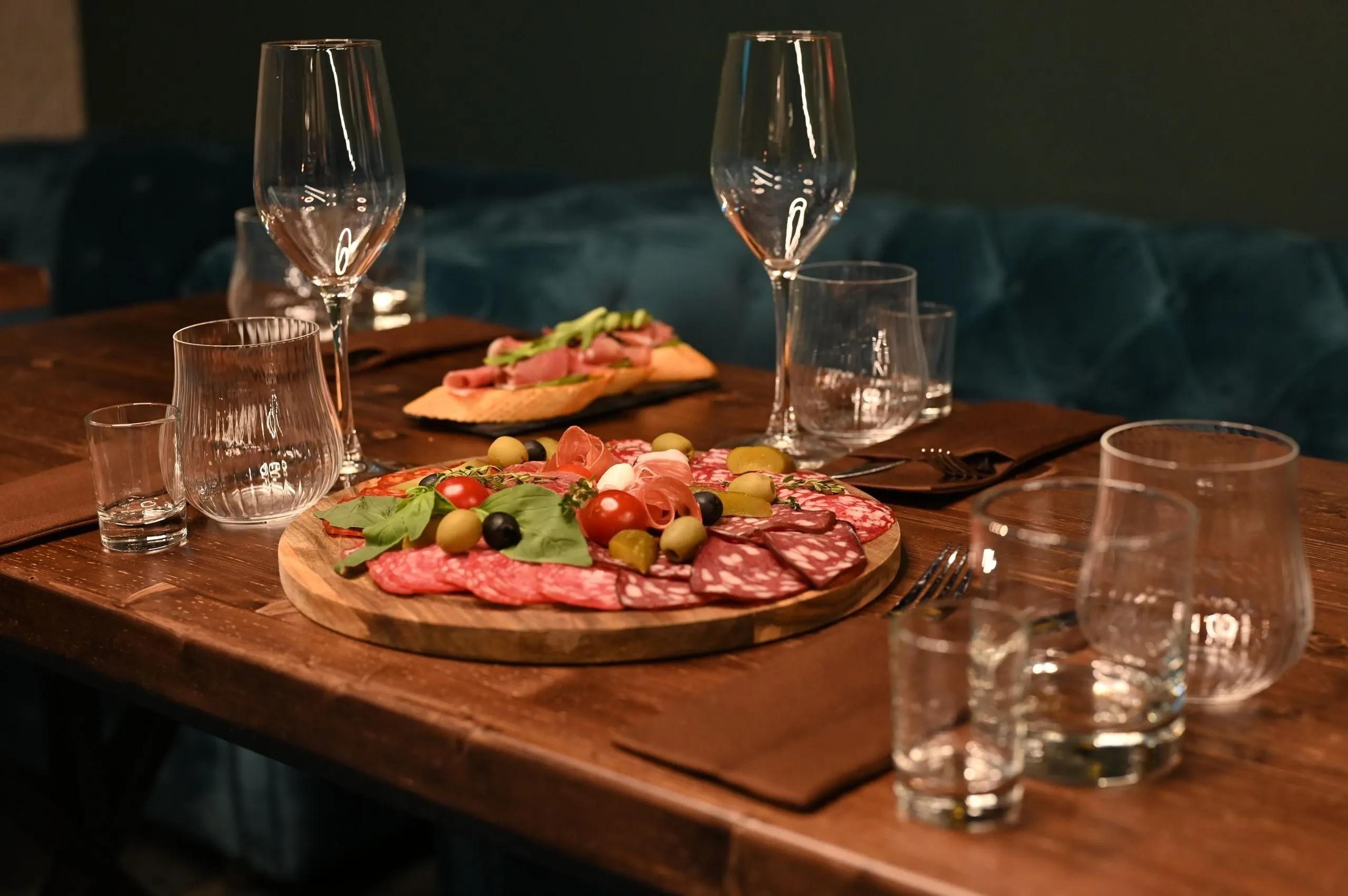 Planche de charcuterie et verres sur une table en bois, le soir