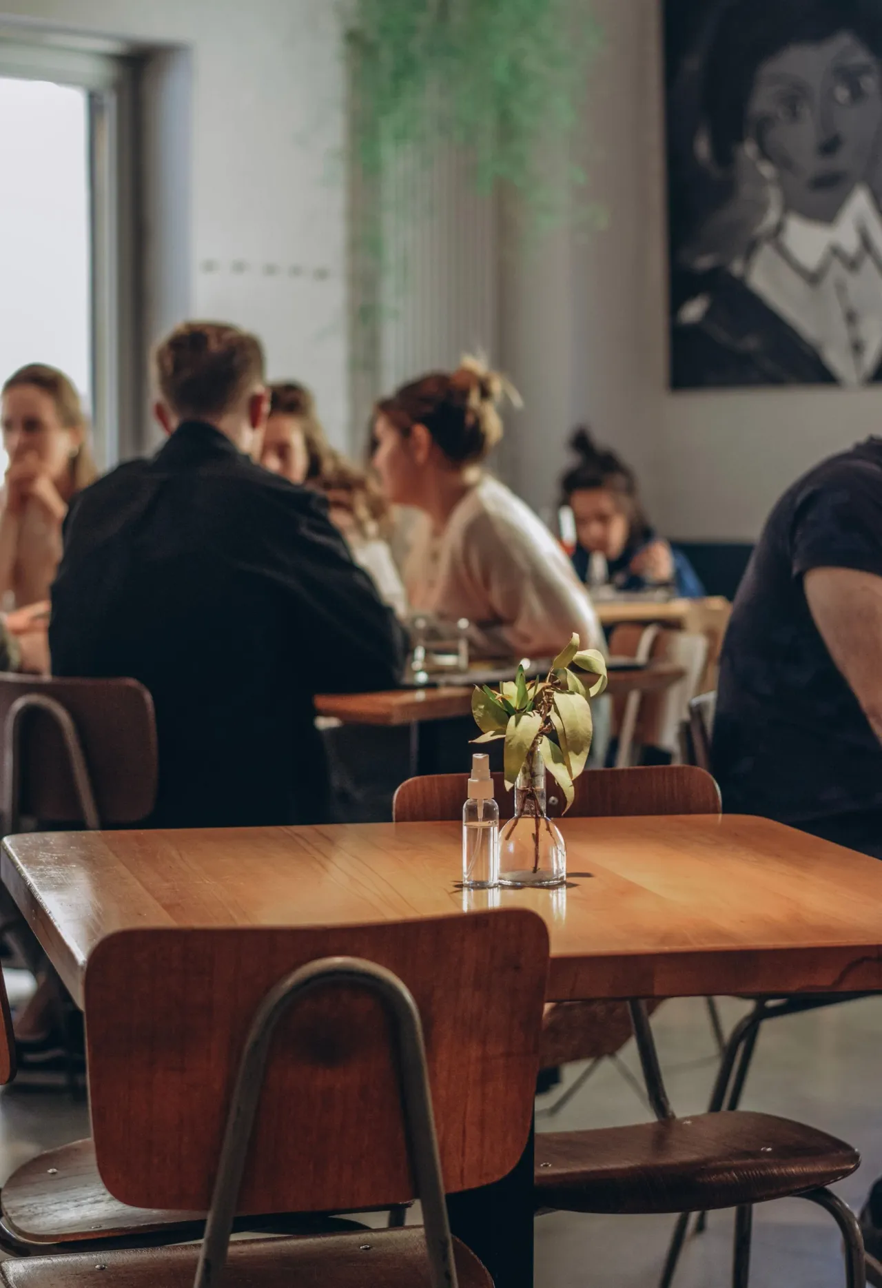 La salle à l'heure du déjeuner, tables en bois et clients attablés