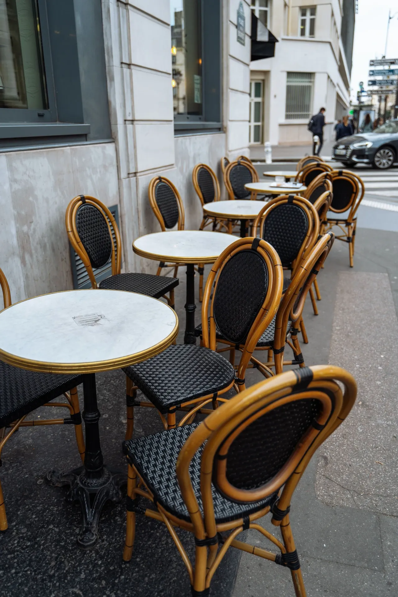 Tables et chaises de bistrot en rotin sur le trottoir