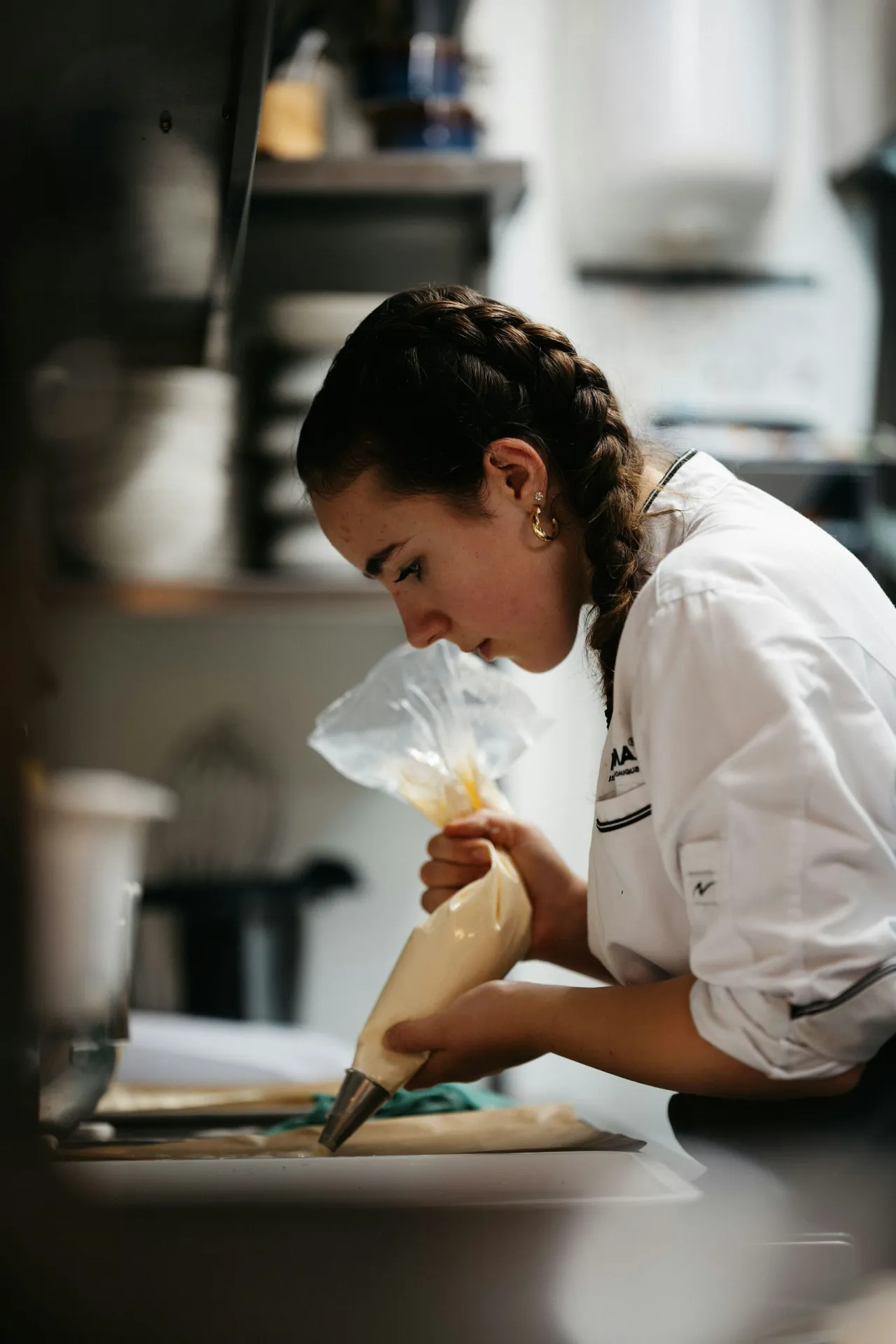 Élise, la cheffe, dresse un dessert à la poche en cuisine